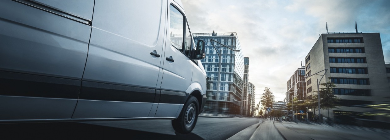 Een bestelauto dat door een stad rijdt